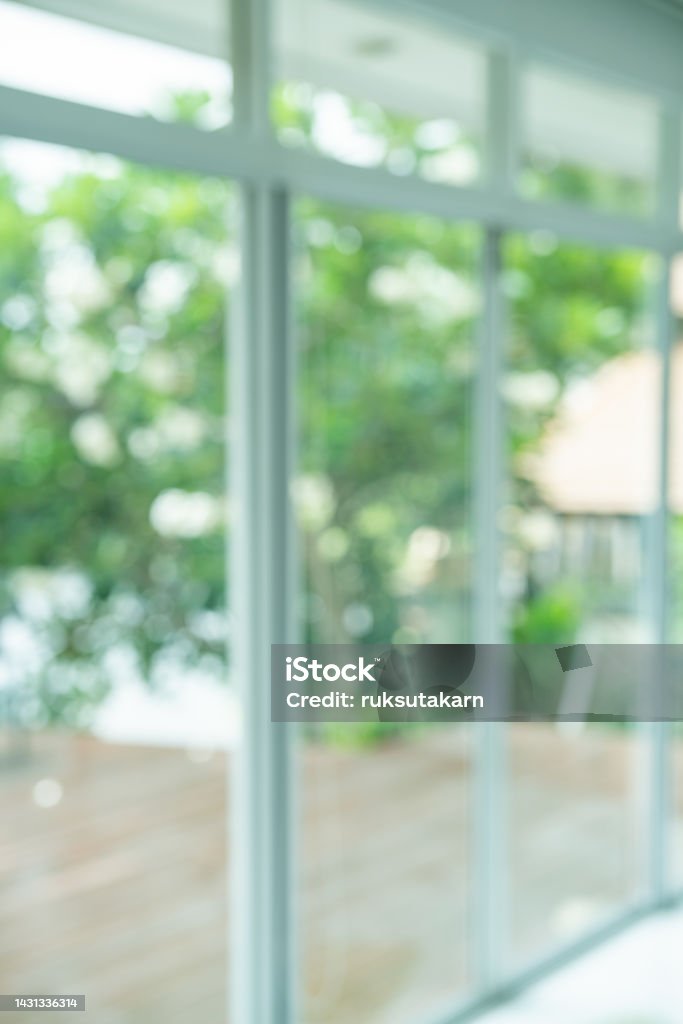 Interior view looking out toward to Green natural garden Blur background, Window view with Blur green bokeh light outdoor natural garden. Backgrounds Stock Photo