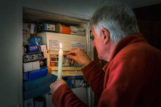 istock Senior man checking home fuse box by candlelight during power outage 1431345952
