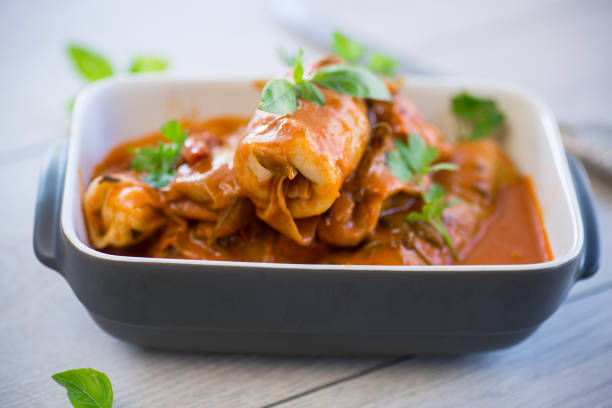 Traditional stuffed cabbage with minced meat and rice, served in a tomato sauce on a wooden table .