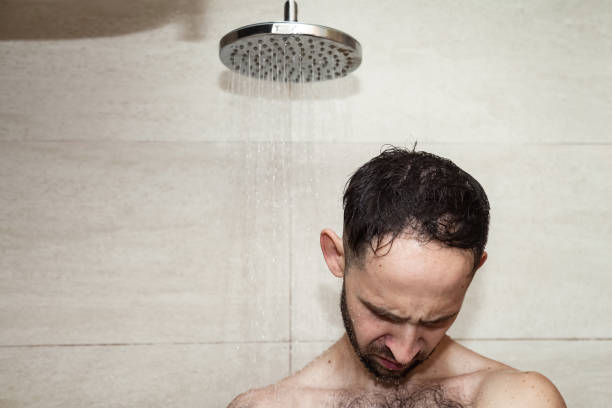 istock Head young bearded man taking shower in bathhouse (sauna) under water falling from rain shower, bathroom. Morning lifestyle guy showering. Concept body care hygiene. Copy text space 1431346162