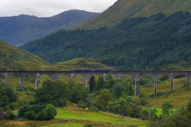 Glenfinnan, Scotland - September 04 2022: A 2 carriage Scotrail train crossing the famous Glenfinnan Viaduct. It operates the scenic West Highland Line route in the Scottish highlands.