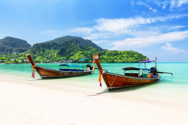 Thai traditional wooden longtail boat and beautiful sand beach at Koh Phi Phi island in Krabi province, Thailand. stock photo