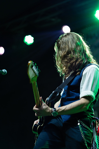 Caucasian ethnicity young adult man playing electric guitar