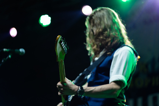 Caucasian ethnicity Young adult man playing electric guitar on stage