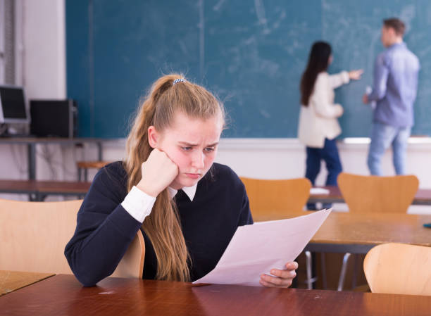 istock Frustrated girl student sitting in classroom with paper 1431353148