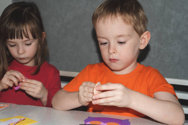 Children making halloween home decorations. Home leisure for children. Preparation for the holiday