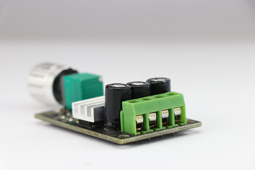DC Motor speed controller board that regulates motor speed using pulse width modulation method kept on a white background