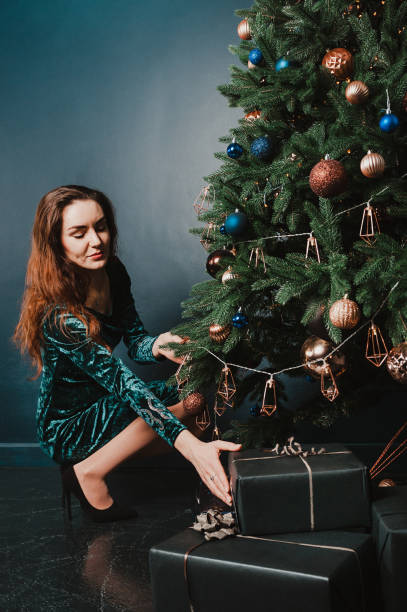istock Pretty young woman decorating Christmas tree 1431355389