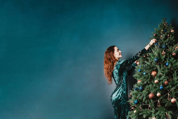 istock Pretty young woman decorating Christmas tree 1431357437