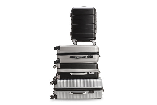 Pile of grey and black hardside suitcases isolated on white background