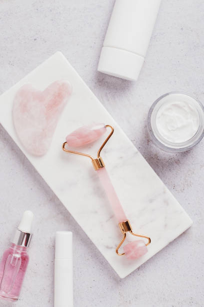 istock Facial roller, gua sha, serum and moisturizing cream on marble background 1431357868