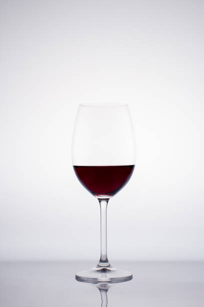 istock Glass of red wine in back light on white background 1431357916