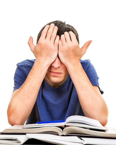 Tired Young Man Rub his Eyes on the School Desk Isolated on the White Background