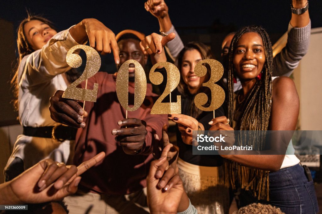 Friends celebrating New Year Party A group of happy friends celebrating New Year together on a rooftop 2023 Stock Photo