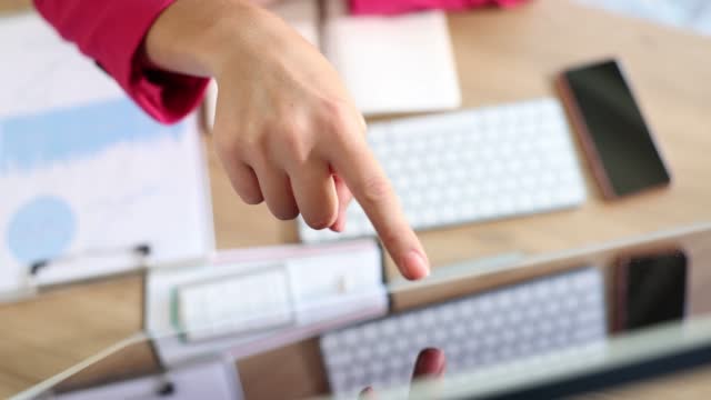 Businesswoman considering important information with one finger on computer