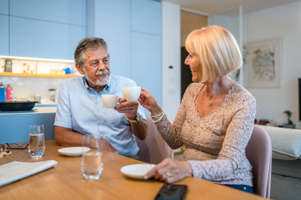 istock Happy Senior Couple Talking And Drinking Coffee In The Kitchen 1431368110