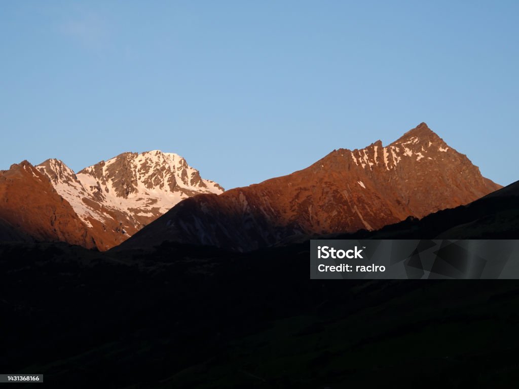 Sunset on the high snow capped peaks above Glenorchy, Routeburn Track. Mount Aspiring National Park, New Zealand. Adventure Stock Photo