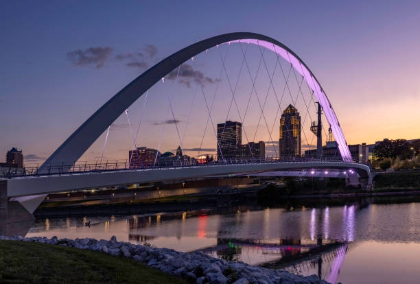 Women of Achievement Bridge at Sunset Women of Achievement Bridge and the Des Moines skyline at Sunset iowa stock pictures, royalty-free photos & images