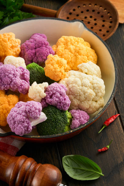 cadre de chou-fleur colorfu. chou-fleur coupé en petits morceaux dans une boîte ou un panier sur un vieux fond de carreaux de pierre grise. maquette de cadre. concept ou contexte de la cuisson des aliments et de la récolte agricole. - purple cauliflower photos et images de collection