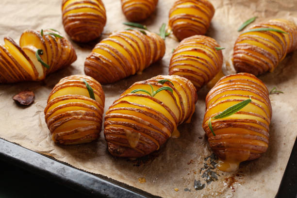 pomme de terre hasselback cuite au four avec fromage cheddar et romarin - prepared potato oven roasted potatoes roasted photos et images de collection