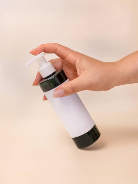 istock A woman hand pumping liquid from a bottle with blank label on light beige close up, mockup 1431377149