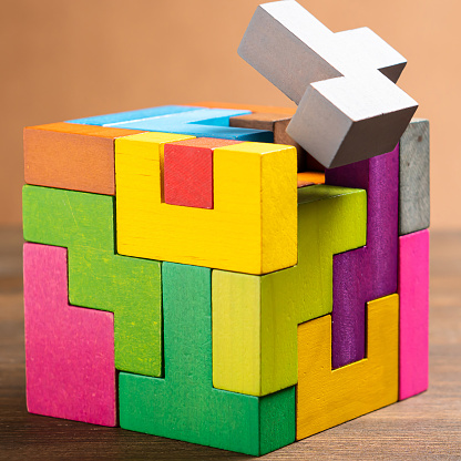 The wooden cube is made of colorful wooden shapes. Geometric shapes in different colors. Logical tasks. Conundrum