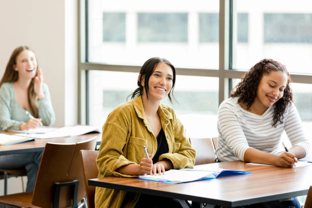 istock Female college students smile and take notes in class 1431383939