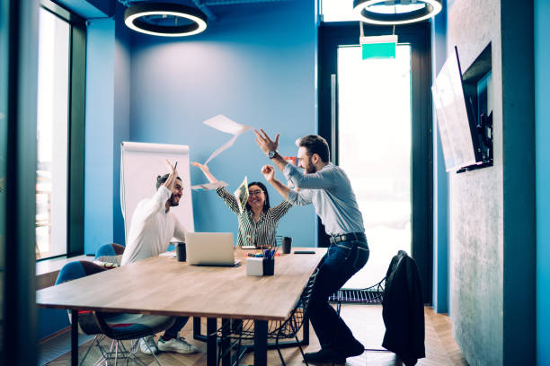 istock Joyful young business people throwing up papers in office 1431384060