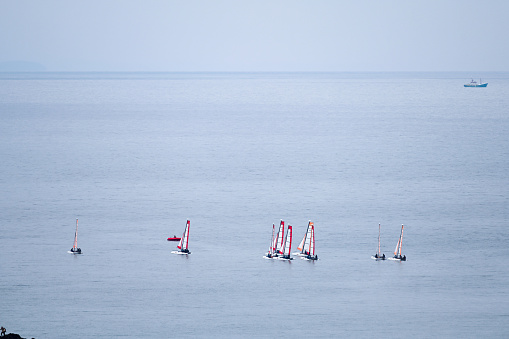 Erquy, France, September 23, 2022 - A group of young people learn catamaran sailing on the coast in the bay of Erquy, Brittany