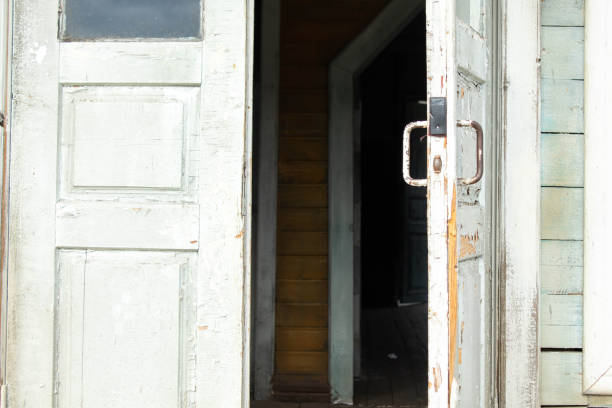 a person opens an old wooden door with a latch.