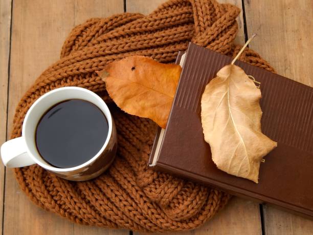 istock Coffee mug, scarf and book on the table 1431397578