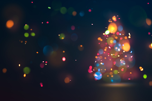 Defocused fir tree with golden bokeh. Blurred Christmas background.