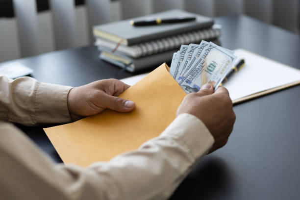 business people in the office receiving wages from work. - bribing imagens e fotografias de stock