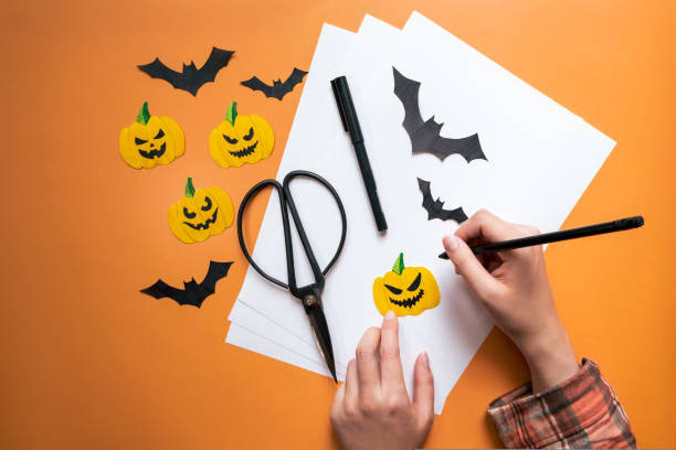 istock A collage layout for the Halloween holiday. Applications, carving figures in the shape of pumpkins and bats. View from above. Hands on the work surface 1431408094