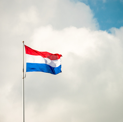 The red, white and blue of a Dutch flag flying in Amsterdam on a sunny day.