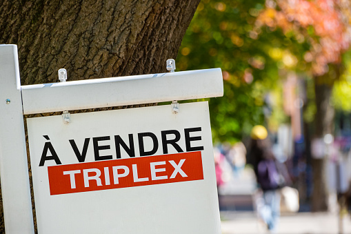 Un letrero de vendre (se vende en francés) frente a una casa photo