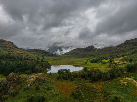 Mist and low cloud envelop the Langdale hills with Blea Tarn in Great Langdale, England, United Kingdom