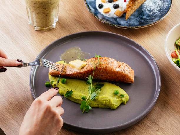 istock the girl has grilled salmon with a side dish 1431421888