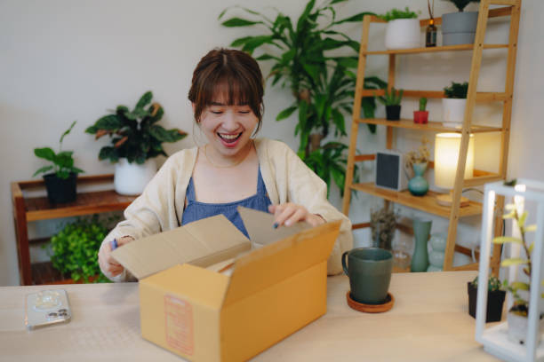 istock Asian Woman owner packing cardboard box get postal parcel. 1431424402