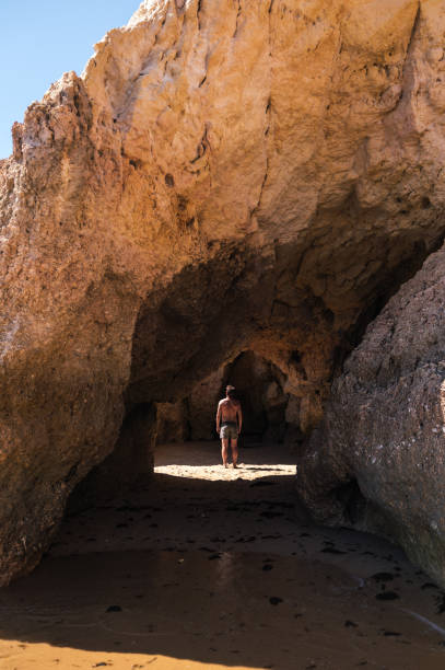 istock Man standing in rocky cave on seashore 1431425337
