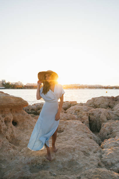 istock Feminine woman strolling on sandy seashore at sundown 1431425441