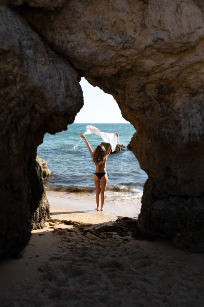 istock Unrecognizable woman on beach with rock 1431427381