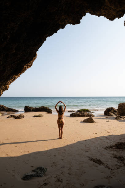 istock Lady in bikini showing heart gesture on sandy beach 1431427419