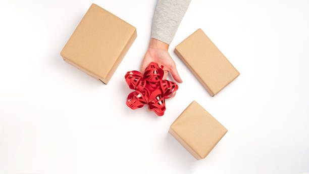 Wrapping kraft box gifts with a red ribbon stock photo