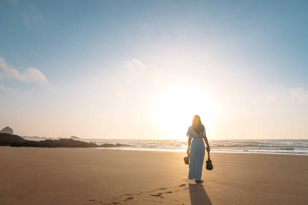 istock Anonymous woman with ukulele standing on beach 1431429801