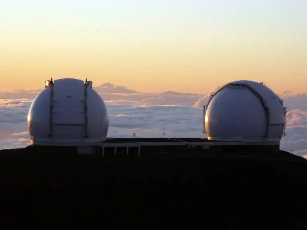 This shot is the scene around the summit of Maunakea in Hawaii Island. We can see a much beatiful sunset behind the grand views of astronomical telescopes.