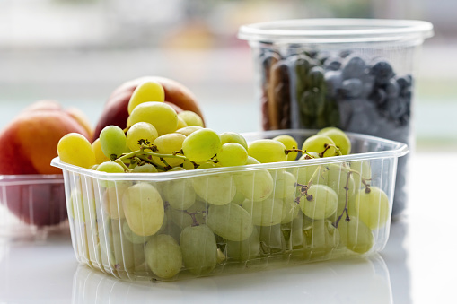 fruits in plastic containers: grapes, nectarines and blueberries