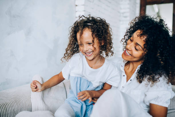 Mother and child playing on home couch Excited playful happy curly kid having fun with cheerful ethnic mom while fooling around together on cozy sofa in apartment puerto rican ethnicity stock pictures, royalty-free photos & images