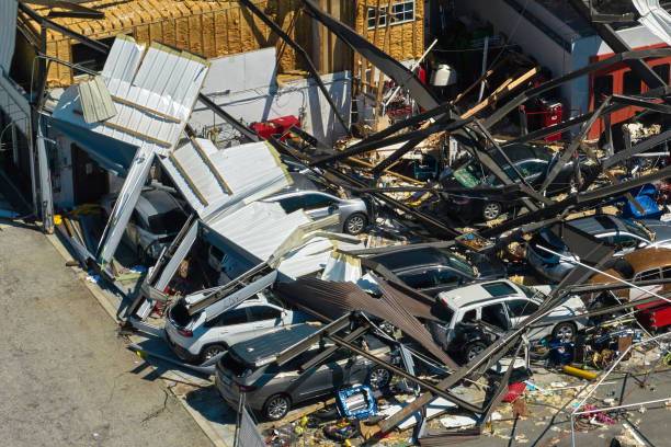 hurricane ian destroyed industrial building with damaged cars under ruins in florida. natural disaster and its consequences - ian stockfoto's en -beelden