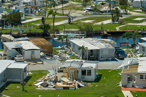Severely damaged houses after hurricane Ian in Florida mobile home residential area. Consequences of natural disaster.